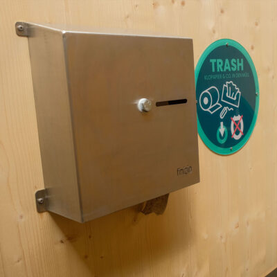 Innenwand des Humero Rollin’ mit Edelstahl-Toilettenpapierspender und grünem Trash-Hinweisschild.