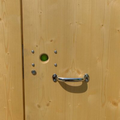 Außentür des Humero Rollin’ aus Holz mit Metallgriff und grünem Tür-Freizeichen.