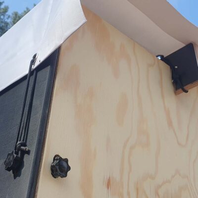 Libre Event 16 Detailansicht der Befestigung der regenfesten weißen Folie am Dach der Libre Event Trockentoilette mit Gummispannern und Schrauben für sicheren Schutz vor Witterung.