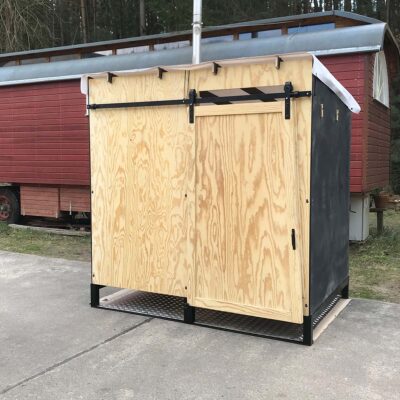 Libre Event 8 Vorderansicht der barrierefreien Libre Event Trockentoilette aus Holz, Fronttür geschlossen, mit regendichtem weißen Foliendach auf Metallbodenplatte für sicheren und komfortablen Einsatz im Outdoor-Bereich.