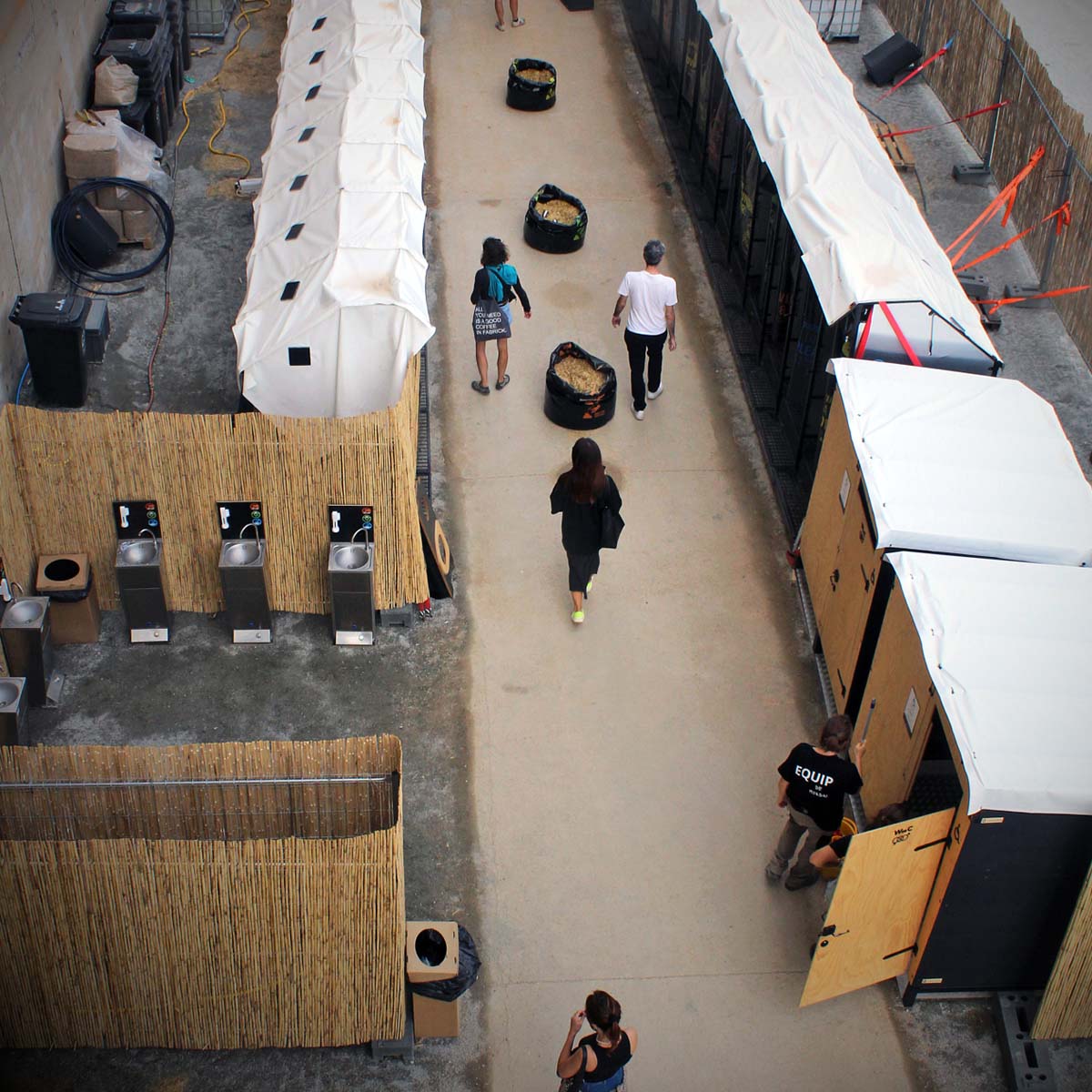 Trockentoiletten und Trenntoiletten 17 Ansicht von oben auf abgesperrten Bereich mit barrierefreien Libre Event Trockentoiletten aus Holz und regendichtem weißen Foliendach sowie Waschstationen bei Veranstaltung