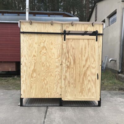 Libre Event 3 Vorderansicht der barrierefreien Libre Event Trockentoilette aus Holz, Fronttür geschlossen, mit regendichtem weißen Foliendach auf Metallbodenplatte für sicheren und komfortablen Einsatz im Outdoor-Bereich.