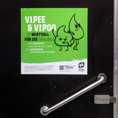 Libre Light 11 Türgriff der Libre aus Edelstahl, darüber grünes Hinweisschild.