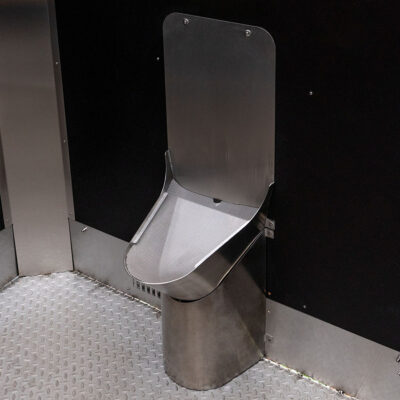 Libre Light 7 Edelstahl-Unisexurinal in der Libre Trockentoilette vor schwarzer Wand.