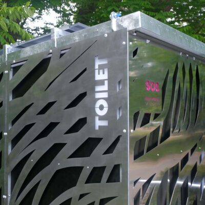 Libre DIN 4 Außenansicht der Libre-DIN Kabine mit Edelstahlverkleidung, beleuchtetem TOILET-Schild und SOS-Logo bei SOS-Notknopfdruck.