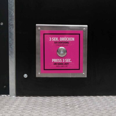 Libre DIN 23 Detailansicht des SOS-Notfallknopfs mit pinkem Hinweisfeld in der rollstuhlgerechten Libre-DIN Trockentoilette.