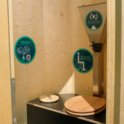 Humero Rollin’ Innenansicht mit Trockentoilette, Holzsitz, Holz-Mülleimerdeckel und Einstreutrichter.