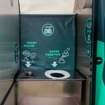 Innenansicht der Humusspähre Trockentoilette von Finizio mit aufgeklebt Toilettensitz Innenansicht Kabine von Humussphäre mit aufgeklebtem Toilettensitz und Hinweisen zur Nutzung, Mülleimer, Toilettenpapierhalterung mit Jumbo-Rolle Toilettenpapier und Hinweisen zur Nutzung.