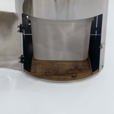 Geöffnete Liloo Trockentoilette aus Edelstahl mit eingesetztem 10-Liter-Feststoffbehälter auf Holzplatte im FSB-Fach.