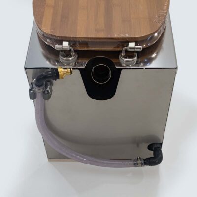 Rückseite der Liloo Trockentoilette aus Edelstahl mit Bambus-Sitz, gesicherter Urinablaufschlauch und Anschlussrohr für Streuspender.