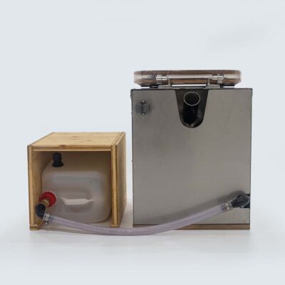 Rückseite der Liloo Trockentoilette aus Edelstahl mit Bambus-Sitz, Urinablaufschlauch zum 10-Liter-Urinkanister im Holz-Beistelltisch und Anschlussrohr für Streuspender.