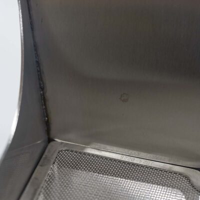Detailansicht der Ecke eines Unisexurinals aus Edelstahl mit eingesetzter Siebeinlage.