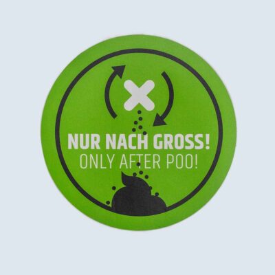 Schilder 11 Rundes grünes Schild mit schwarzem Piktogramm und Text „Nur nach Groß!/ Only after poo!“.