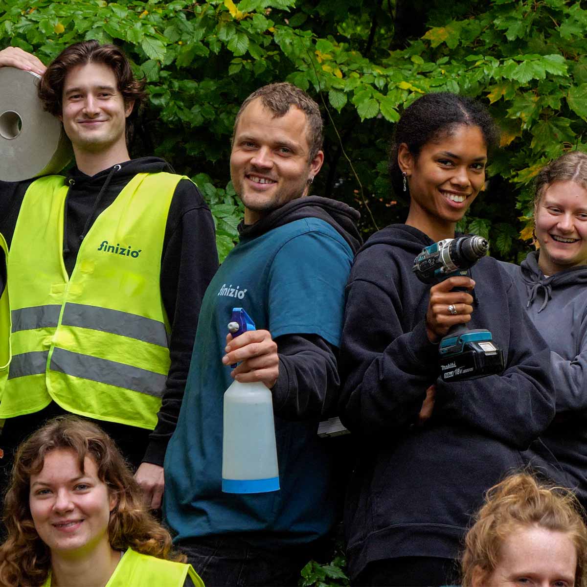 Startseite 18 Mitarbeiter von Finizio im Einsatz mit Akkuschrauber, Putzzeug und Arbeitskleidung.