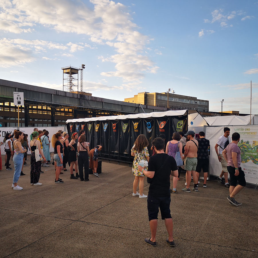 Humussphären-Trockentoiletten von Finizio auf der Veranstaltung am Tempelhof 2022, Menschen warten draußen in der Schlange.