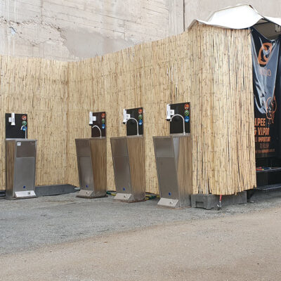 Mehrere Handwaschstationen Watergate vor Bambuswand bei der Manifesta in Barcelona.