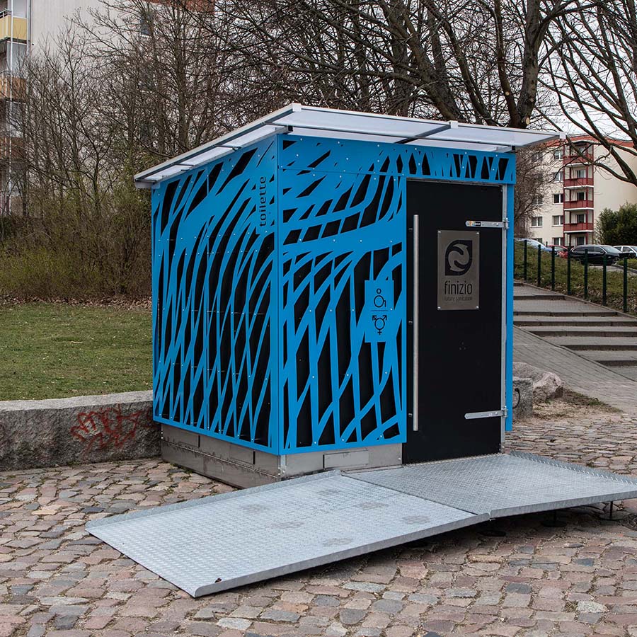 Trockentoiletten und Trenntoiletten 18 Außenansicht Humero Rollin’ auf Trailer links und Humero Trockentoilette rechts vor grünem Wald
